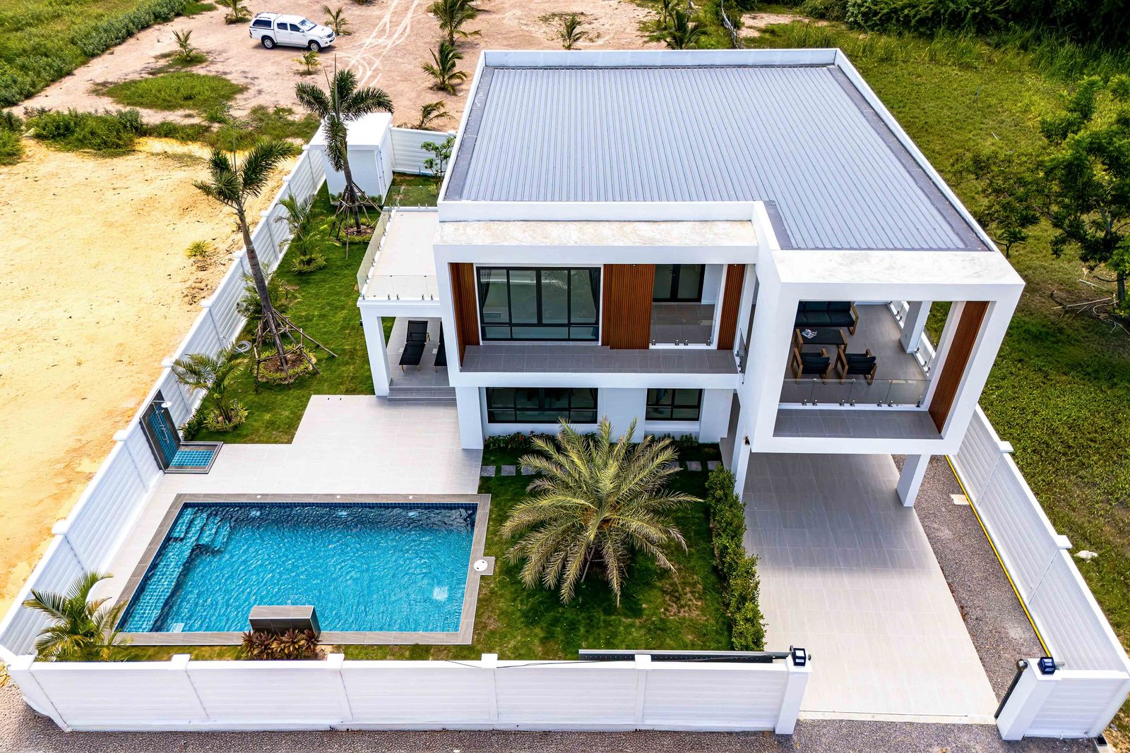 Aerial view of a finished house with pool and walled garden, Soi 102